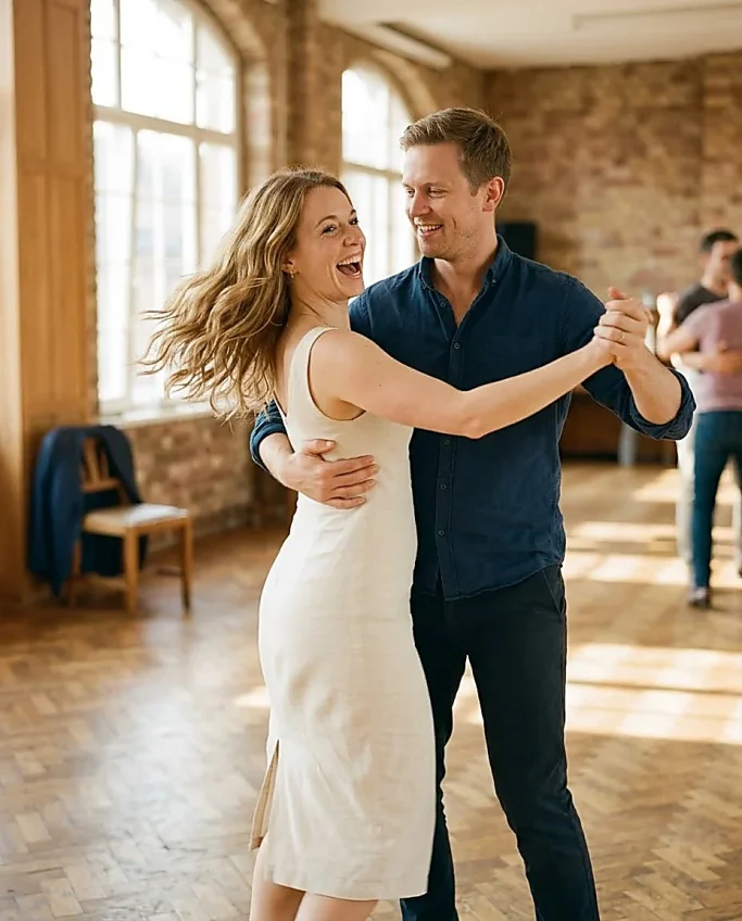 Dancing couple laughing in sun-filled dance studio – AI-generated image for dance school and events.