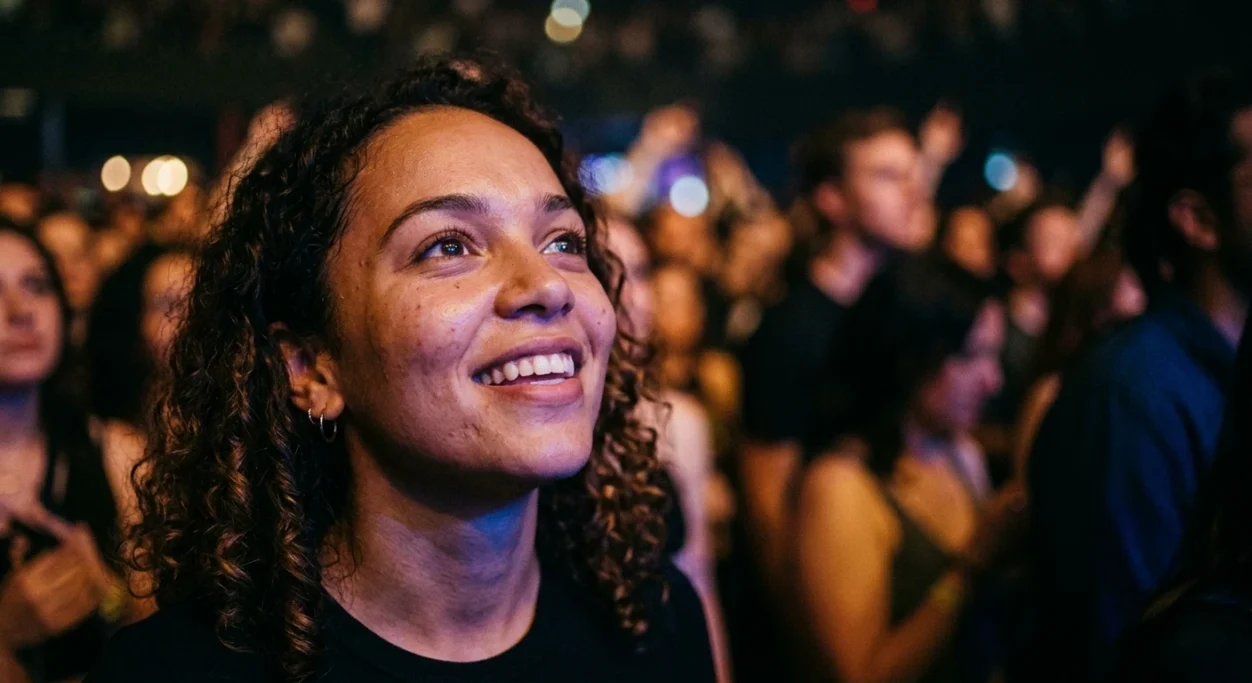 Woman smiling in the crowd at a concert – AI ad image for events and cultural brands.