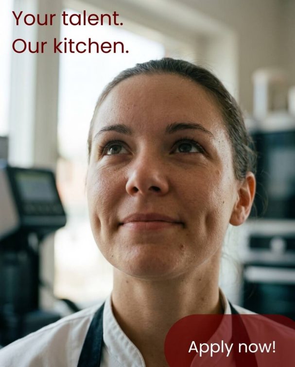 Proud female chef in a commercial kitchen – premium AI-generated marketing visual for recruiting in restaurants and the gastronomy sector.